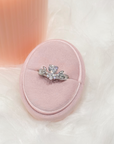 Hannah ring with a heart-shaped clear centre stone and leaf-like accents in a pink velvet ring box.